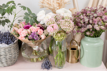 Few of beautiful luxury bouquet. Mixed flowers on pink table. the work of the florist at a flower shop. Wedding