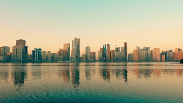 Panning along coast of Khalid lake. Skyline with skyscrapers. Al Noor island in Sharjah, UAE.