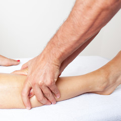 Fototapeta premium Masseur giving a lower thigh massage