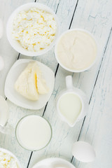 Different dairy products on the white wooden background