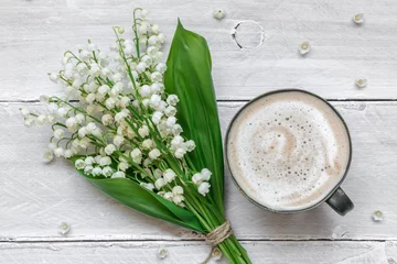Zelfklevend Fotobehang spring lily of the valley flowers bouquet with cup of coffee with milk © samael334