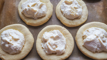 Cheese buns with cheese on a baking sheet. Homemade pastries.
