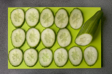 Sliced cucumber on cutting board. Fresh cucumber slices, top view.