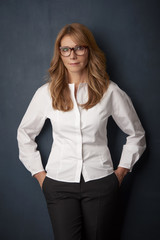 Attractive middle aged woman with toothy smile posing at studio against isolated background