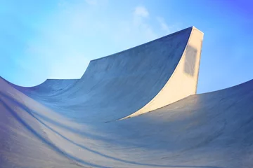 Abwaschbare Fototapete generic skatepark ramps low view to show scale with blue saturation © barneyboogles