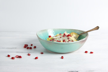 Superfood millet porridge with matcha chia pudding, pomegranate seeds and coconut flakes