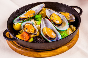 Mussels with vegetables in cast-iron black pot