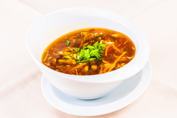 Chinese spicy and sour soup with chicken in white plate