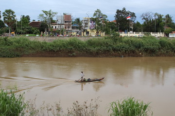 Local man rows his boat downstream in Battambang, Cambodia