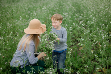 Happy mom and son play in the park in spring.