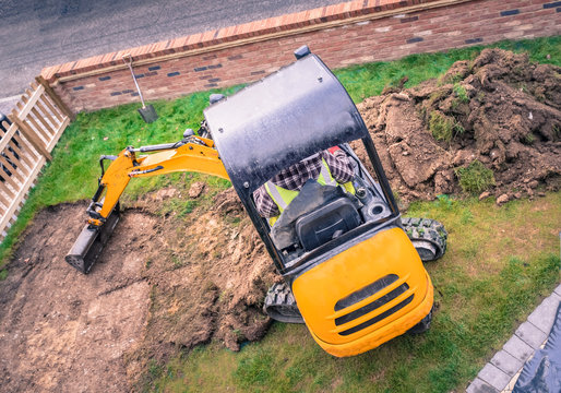 Mechanical Digger Seen From Above Removing Turf In Front Yard, Garden For Landscaping With Artifical Grass.