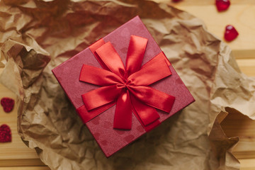 A gift in a beautiful crane box tied with a ribbon on a wooden surface.
