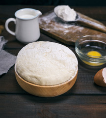 wheat yeast dough in a wooden bowl