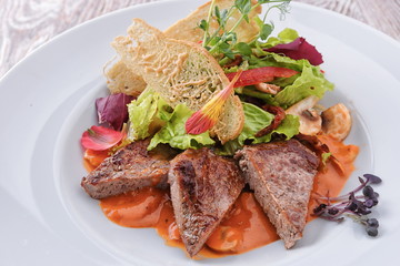 Slices of meat with vegetables and mushrooms