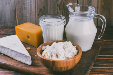 Dairy products on a rustic wooden table. Fresh milk and cheese
