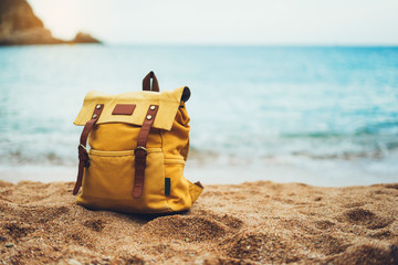 hiker tourist yellow backpack closeup on background blue sea enjoying sunset ocean horizon, blurred panoramic seascape sunrise blank, traveler relax holiday concept, sunlight view in trip vacation - obrazy, fototapety, plakaty
