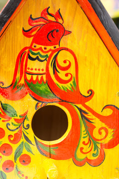 culture, environment, art concept. there is a colorful firebird painted on the golden surface of nesting box, it is made in old russian traditions of art called khokhloma