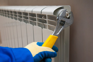 Hands with wrench near radiator