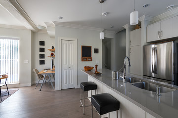 Modern white kitchen with stainless steel appliances and small office. Interior design.