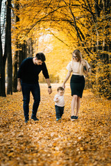 Family playing in autumn park having fun