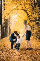 Family playing in autumn park having fun