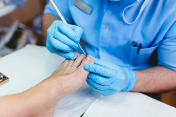 Doctor specialist giving pedicure treatment to his patient.