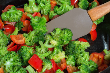 stirring of stewed vegetables, in a frying pan, vegetarian cuisine