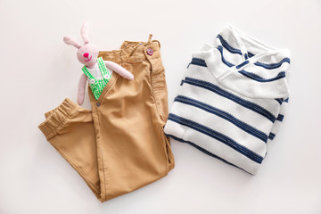 Composition with fashionable childish clothes on white background