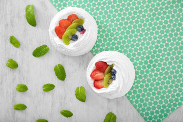 Tasty Pavlova cakes on wooden table