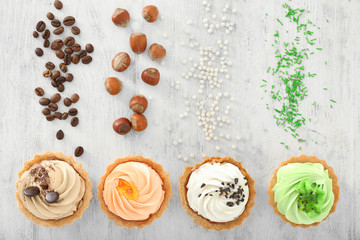 Assortment of tasty tartlets on wooden background, flat lay