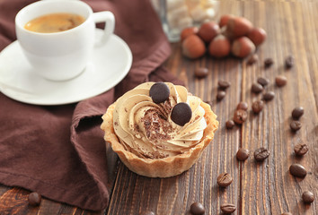 Tasty tartlet with whipped cream on wooden table