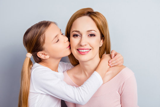 Growing-up beauty positivity respect gentle emotions health care concept. Close up portrait of pretty adorable nice mommy and small lovely girl kissing cheek hugging neck isolated on gray background