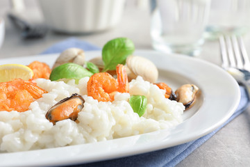 Plate with delicious seafood risotto on table, closeup