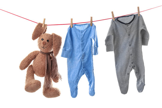 Children's Clothes And Toy On Laundry Line Against White Background