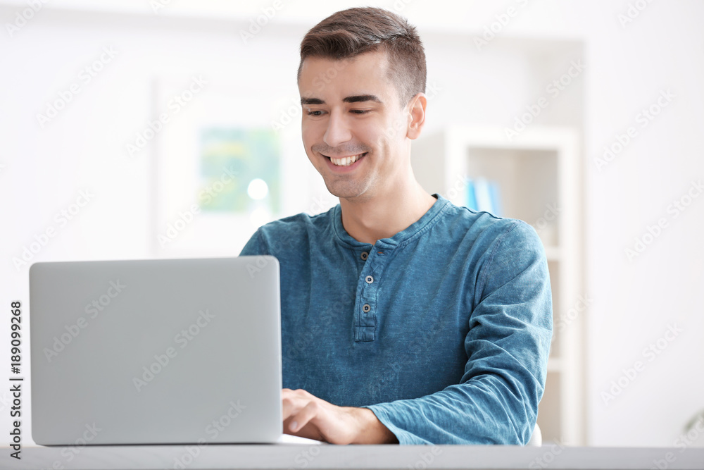 Canvas Prints Young man using modern laptop at table