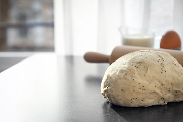 Raw dough with poppy seeds on table