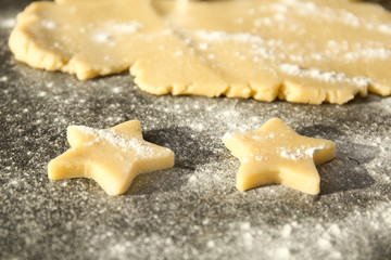 Fototapeta na wymiar Cutting cookies from raw dough on table