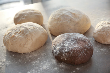 Fototapeta na wymiar Balls of different raw dough on table