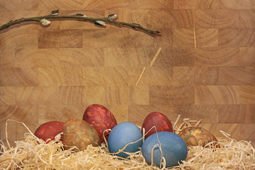 Hand-painted Easter eggs on a wooden background with straw