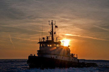 tugboat in Lake Michigan ice at sunset - obrazy, fototapety, plakaty