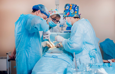 Group of surgeons in operating room with surgery equipment.