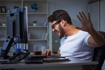 Young man staying late in office to do overtime work