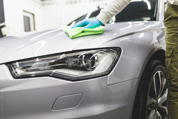 Obraz na płótnie Canvas A man cleaning car with microfiber cloth, car detailing (or valeting) concept. Selective focus. 