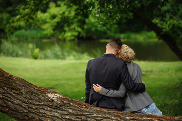 Happy marriage. Wedding in rustic style. Bride and groom embracing and looks to future in forest. Togetherness concept