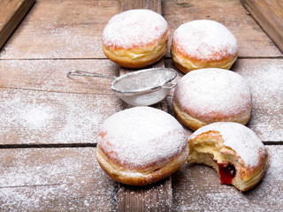 Traditional Polish donuts on wooden powder. Tasty doughnuts with jam.