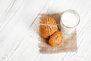 A glass of milk and delicious oatmeal cookies. Top view. The con
