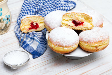 Traditional Polish donuts on wooden powder. Tasty doughnuts with jam.