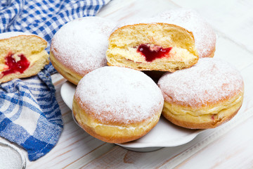 Traditional Polish donuts on wooden background. Tasty doughnuts with jam.