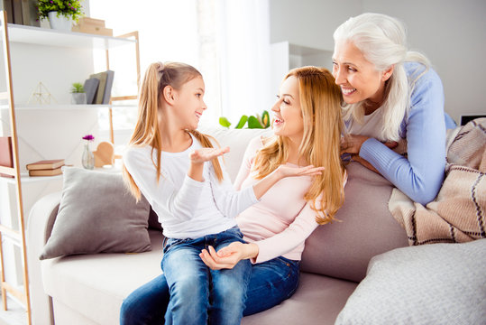 Communication tenderness day-off weekend comfort concept. Cute lovely sweet adorable girl funny schoolgirl sitting mum's knees telling story about school excited cheerful mom and granny are listening
