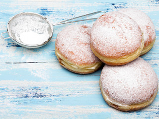 Traditional Polish donuts on wooden powder. Tasty doughnuts with jam.